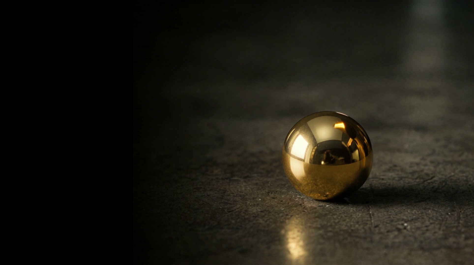 A solid gold orb at rest on dark stone, the final frame of the ORB Legacy film.