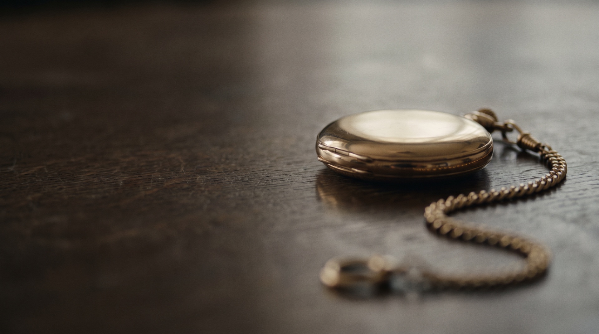 An heirloom gold pocket watch resting on dark stone.